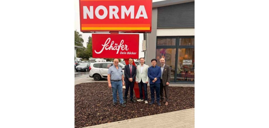 Fünf Männer stehend vor einem Supermarkt