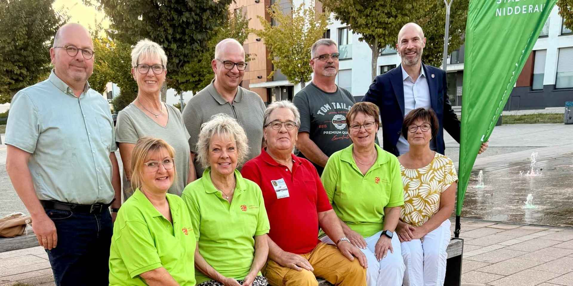 Mehrere Personen sitzend und stehend auf dem einem Stadtplatz