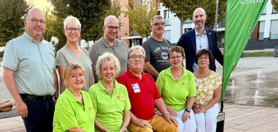 Mehrere Personen sitzend und stehend auf dem einem Stadtplatz