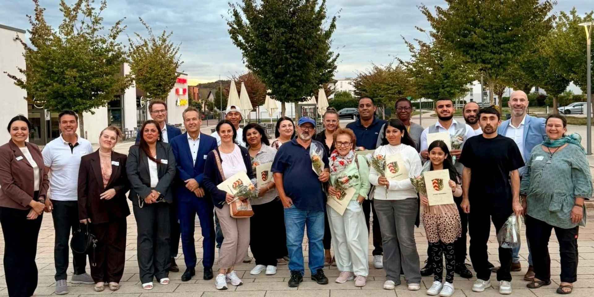 Mehrere Personen nebeneinander stehend auf einem Stadtplatz