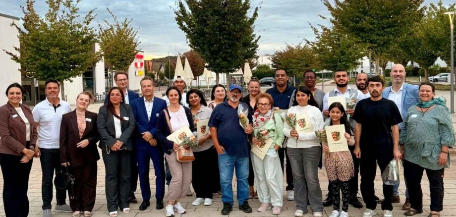 Mehrere Personen nebeneinander stehend auf einem Stadtplatz