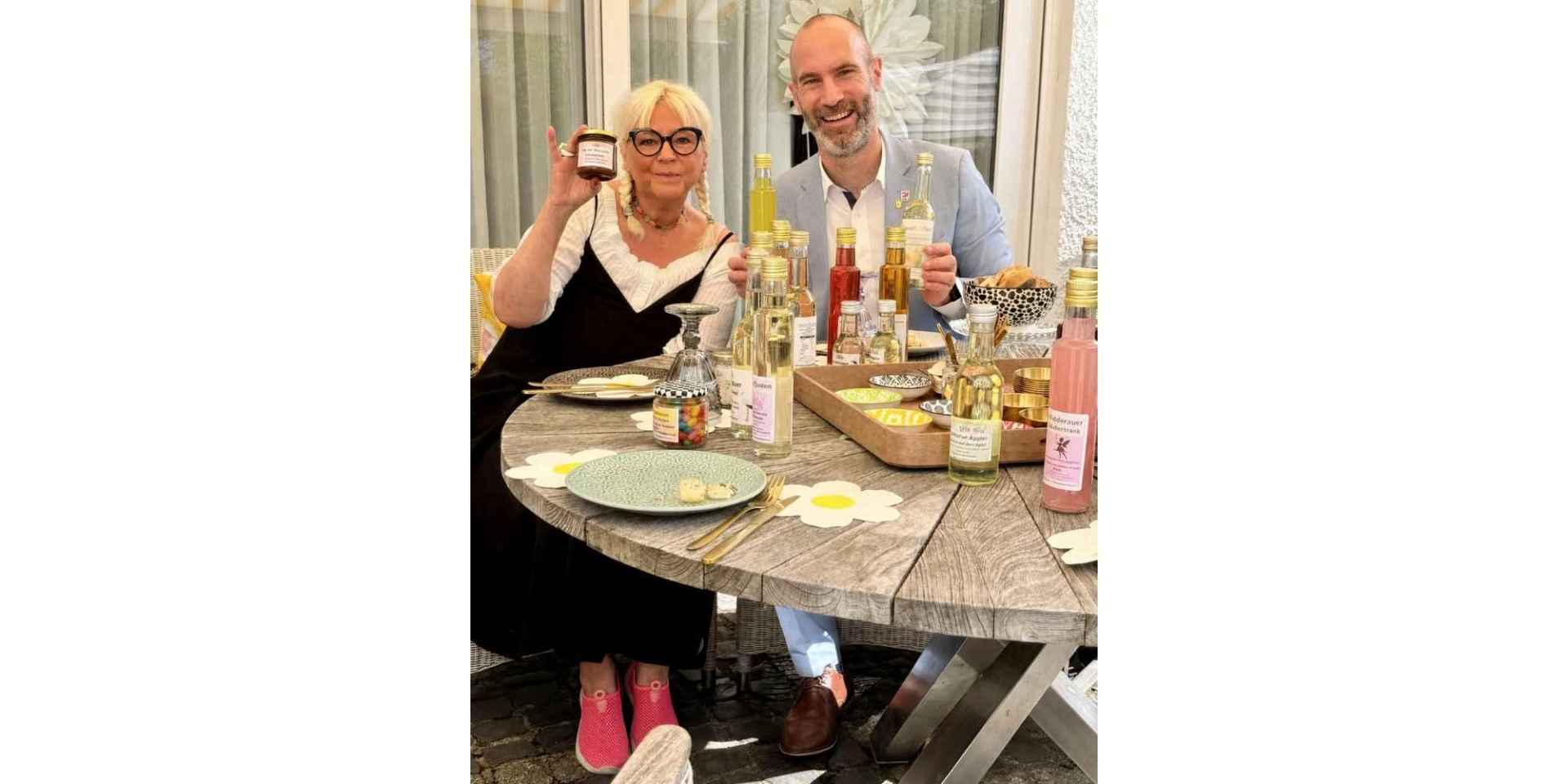Eine Frau und ein Mann sitzen an einem Tisch mit einem Delikatessenangebot