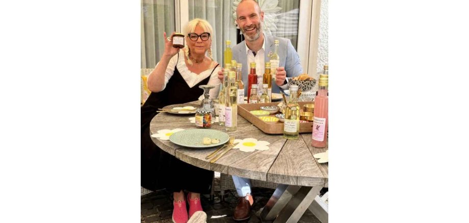 Eine Frau und ein Mann sitzen an einem Tisch mit einem Delikatessenangebot
