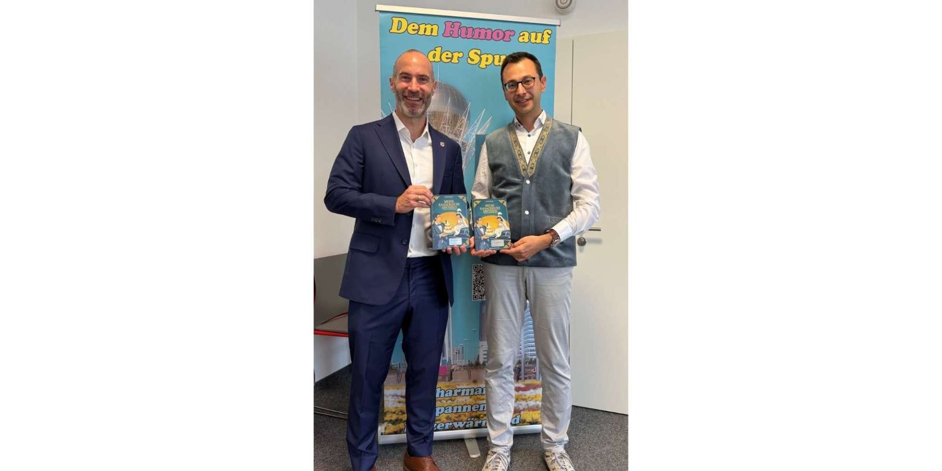 Zwei Männer stehen nebeneinander. Beide halten jeweils ein Buch in der Hand