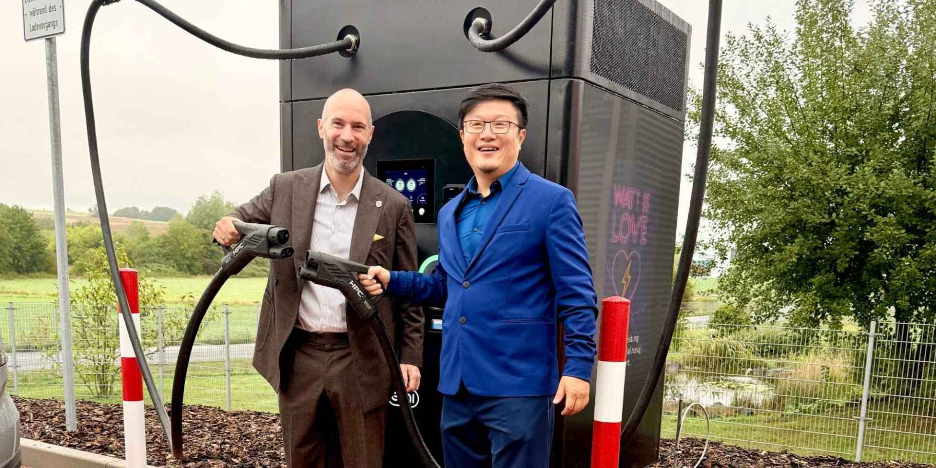 Zwei Männer vor einer Schnellladesäule für Elektroautos