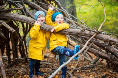 Zwei Kinder spielend im Wald mit Holzstöcken