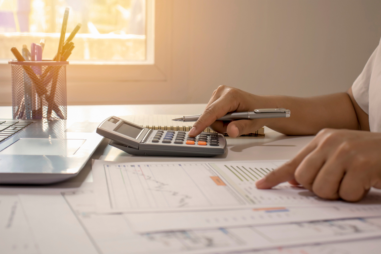 Close-up of businessmen or accountants holding a pen and pressing on the calculator to calculate business information, accounting documents, business ideas. Hand auf Taschenrechner