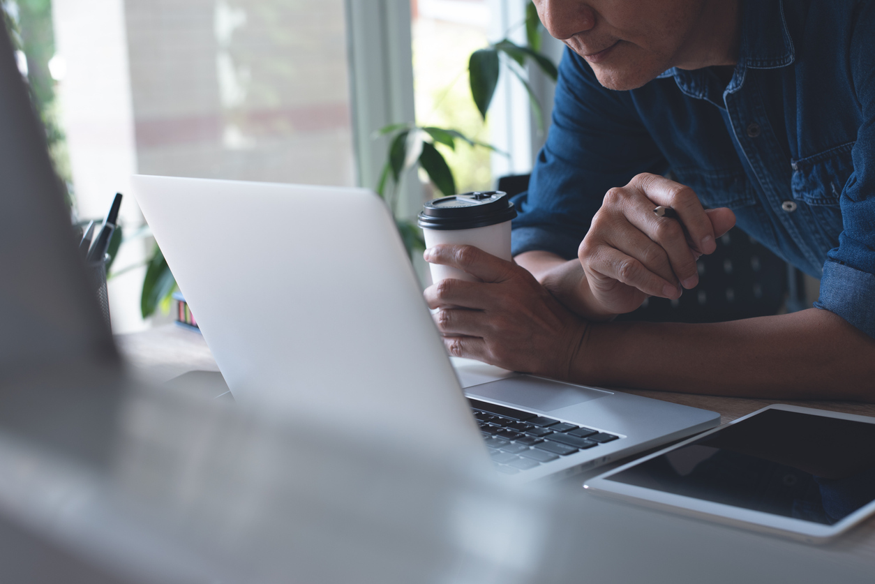 Mann mit Kaffee und Laptop