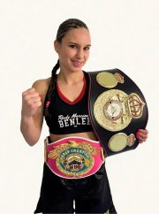 Boxerin hält eine Hand zur Faust geballt und lächelt