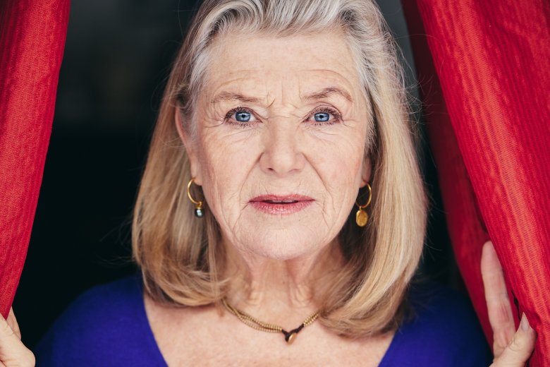 Blonde Frau vor dunklem Hintergrund