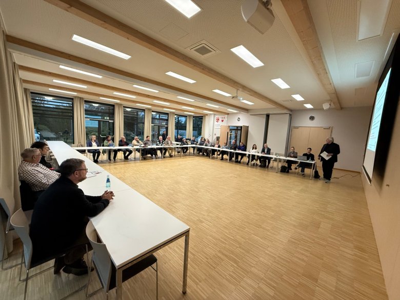 Mehrere Personen in einem Saal sitzend 