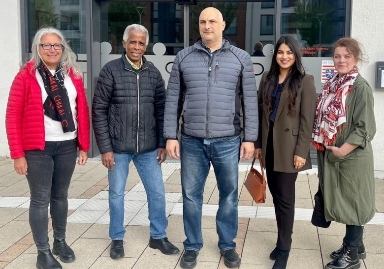 Fünf Menschen stehend vor dem Eingang des Familienzentrums