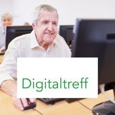 Senior sitzt an Computer mit Textbox "Digitaltreff"