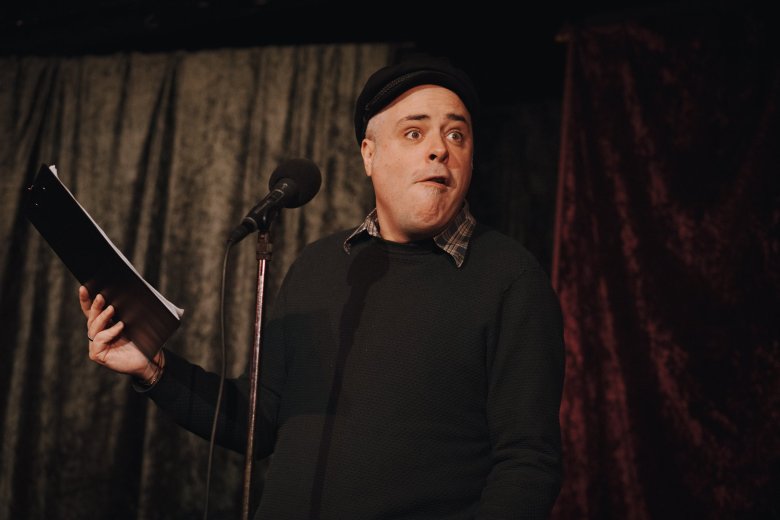 Mann in schwarz gekleidet auf einer Bühne